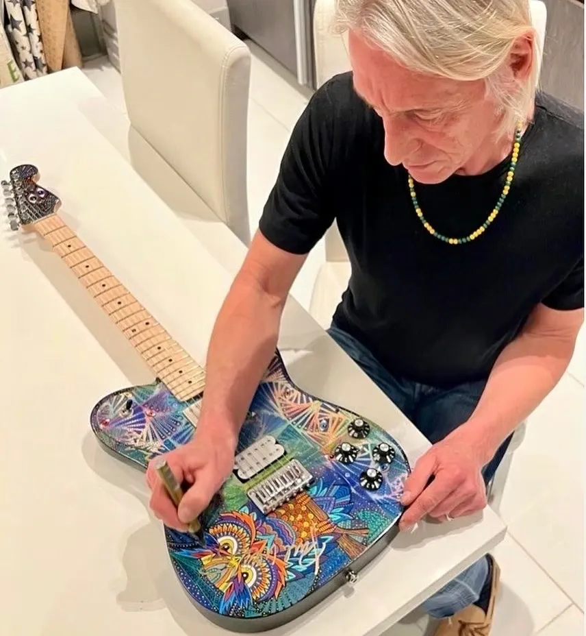 Paul Weller signing Nancy Elhallak painted guitar